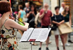 woman playing violin to crowd "in tune for pregnancy with fertility coaching and psychotherapy